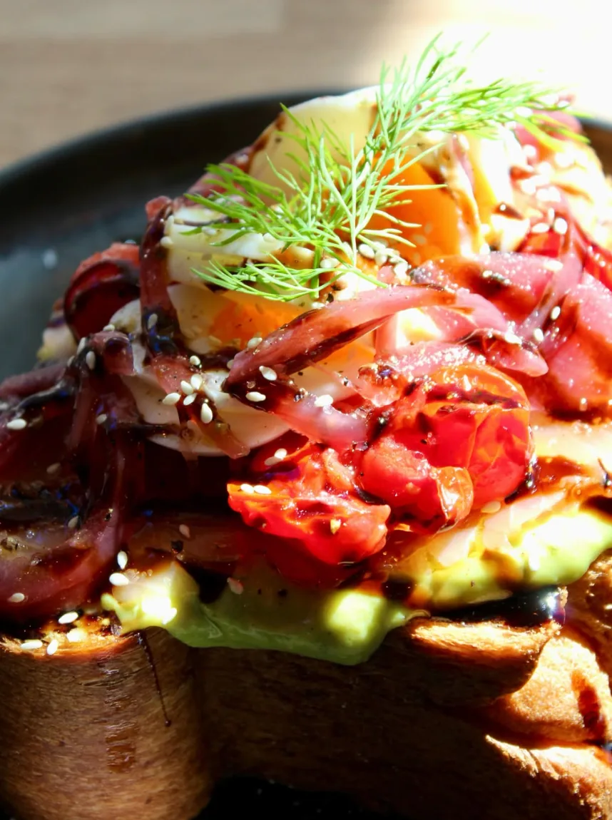 The Creamy Avocado: brioche with avocado yoghurt, roasted tomatoes, caramelised onions, egg, sesame and dill